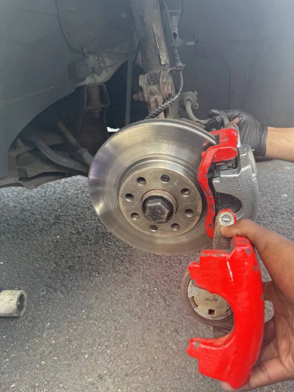 Brake disc and caliper removed during a mobile brake job